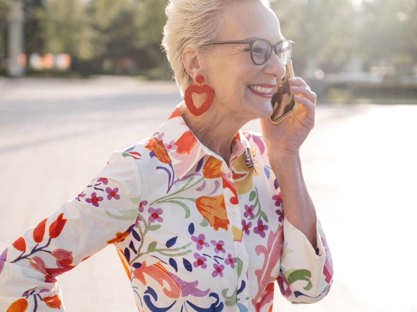 A cheerful woman smiling during a phone call on a sunny day
